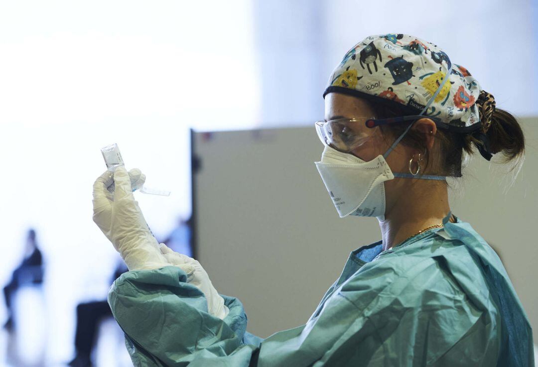 Una profesional sanitaria sostiene un vial con la vacuna de AstraZeneca