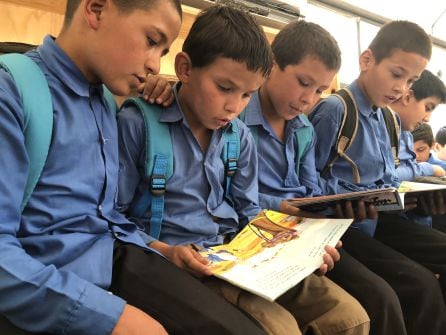 Un grupo de niños leen libros en el autobús-biblioteca