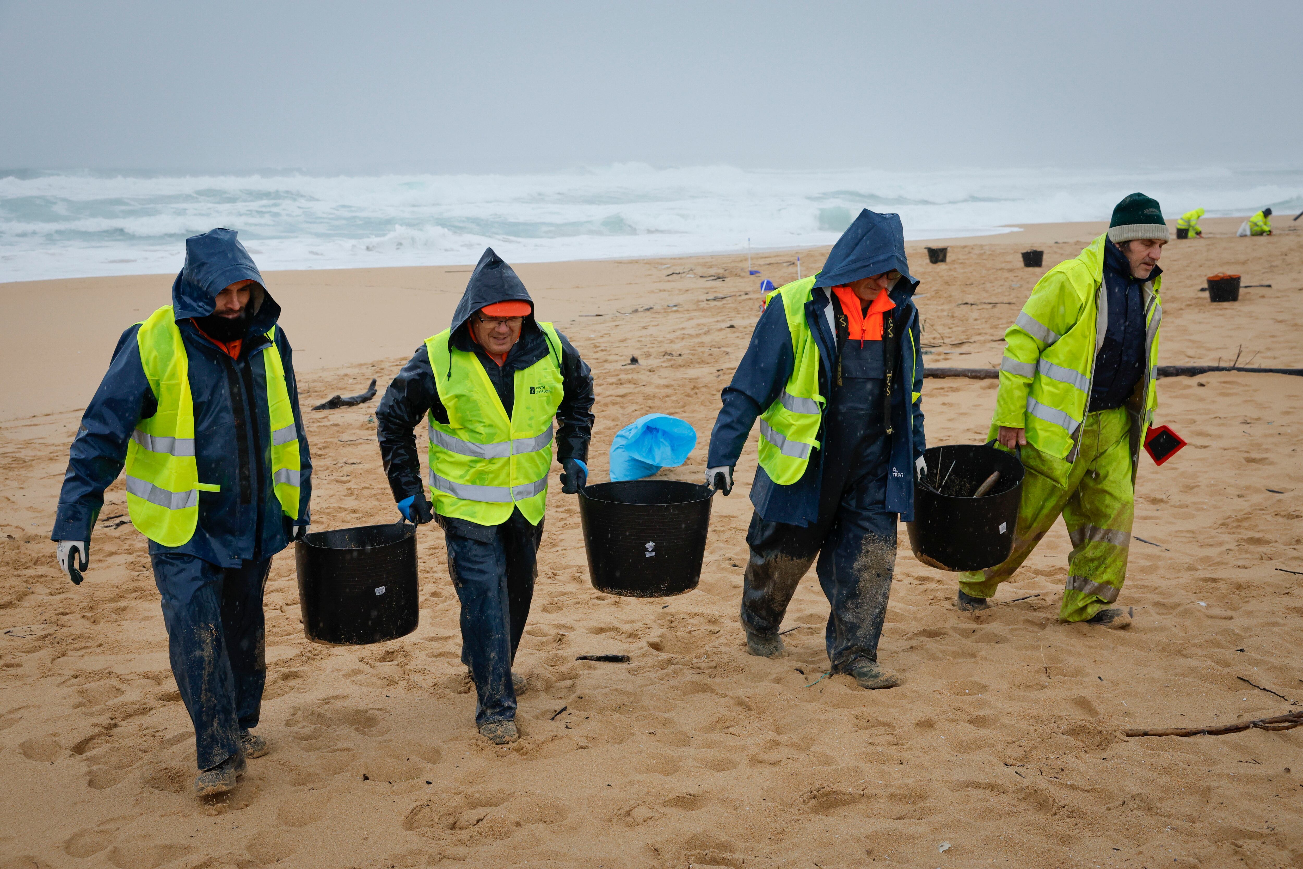 RIBEIRA (A CORUÑA), 09/01/2024.- Operarios de empresas contratadas por la Xunta retiran los pellets o bolitas para fabricar plástico que aparecen en las playas gallegas y de Asturias, tras la caída de un contenedor de un barco el pasado diciembre, esta mañana en la playa de O Vilar, en el parque natural de Corrubedo, A Coruña. EFE/Lavandeira jr
