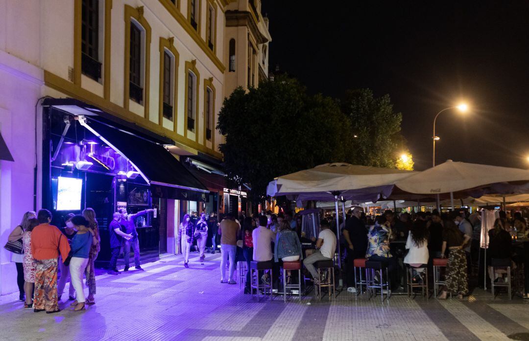 Algunos clientes aguardan para acceder al interior de un bar de copas de Sevilla