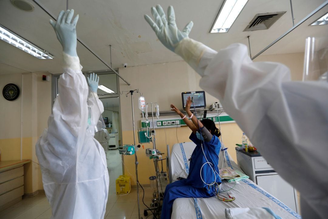 Personal sanitario con una paciente en una habitación hospitalaria