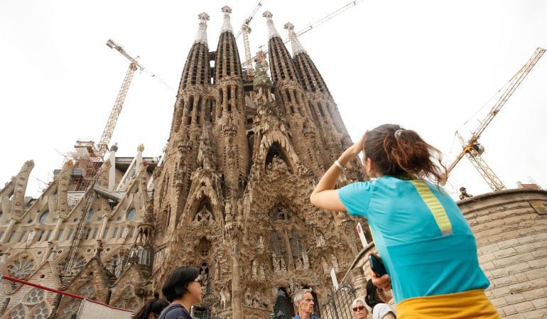 Una mujer fotografía a la Sagrada Familia