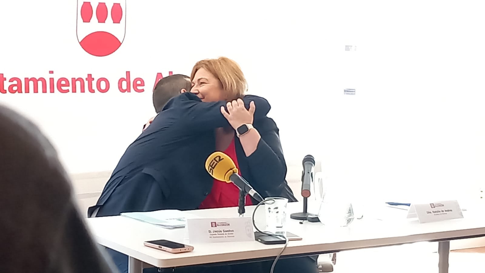 La alcaldesa de Alcorcón, Natalia de Andrés y el 2º Teniente de Alcalde, Jesús Santos se abrazan tras el anuncio de la creación del servicio ATENPRO en el CREAA