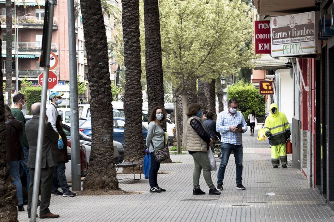 Colas a las puertas de una carnicería de Gandia y un operario desinfectando las calles 