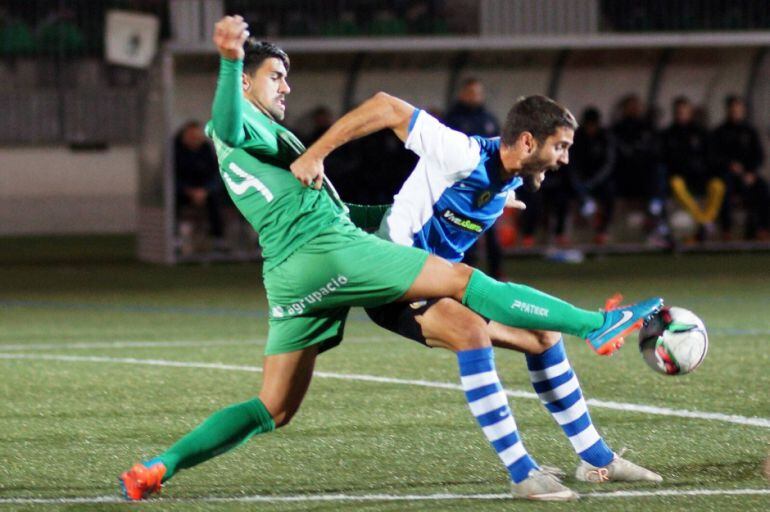 Mariano, jugador del Hércules CF, pelea un balón con el defensa de Cornellà
