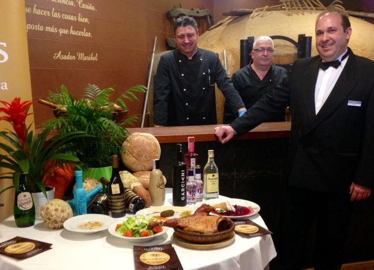 El equipo de Restaurante Maribel posa junto al horno de leña y el menú de las jornadas