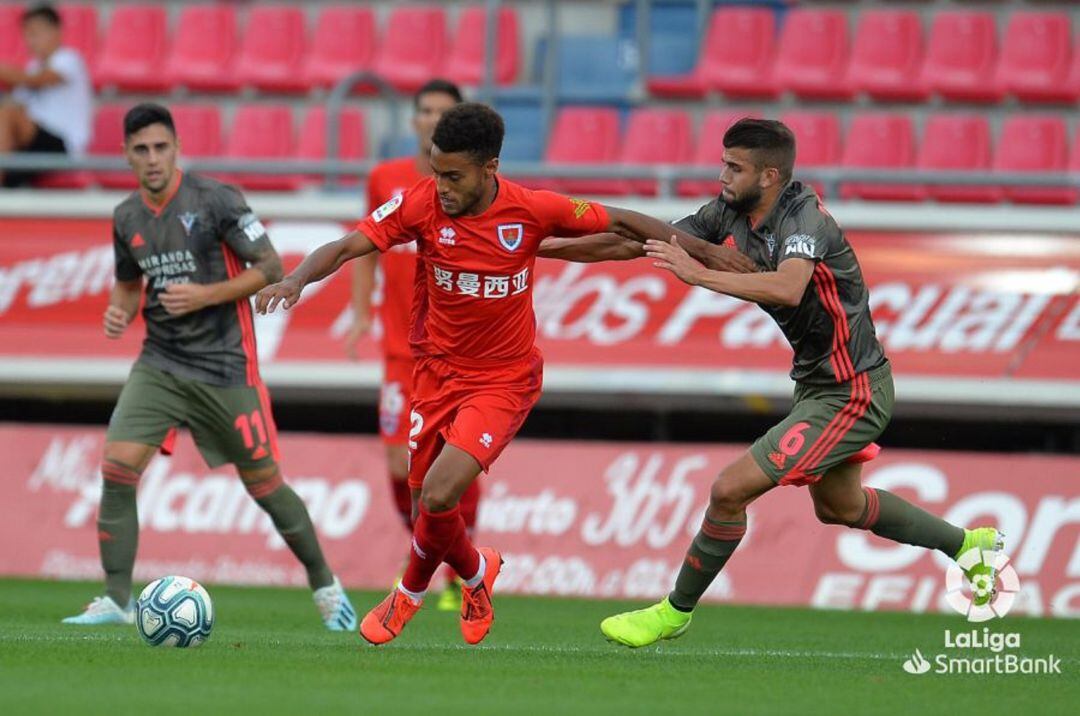 Antonio Otegui, que debutó con el Numancia, conduce el esférico ante la presión de Mohedano.