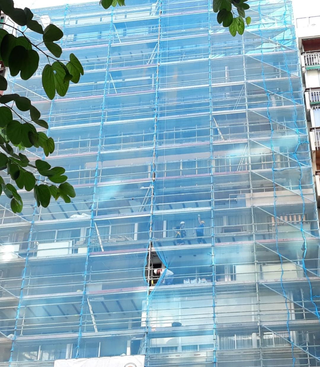 Obreros trabajando en la rehabilitación de la fachada de un edificio en Alicante