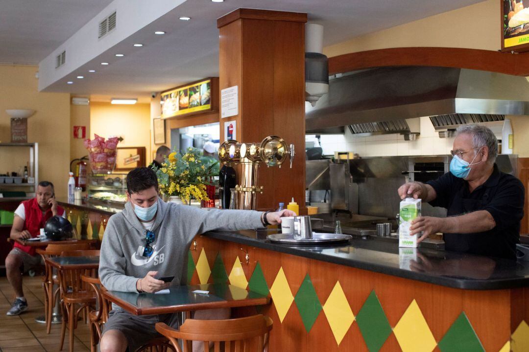Un hombre se toma un café en un bar de Barcelona este lunes 