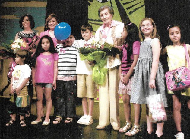 Manolita Espinosa, en el centro con niños y niñas en el teatro de Almagro