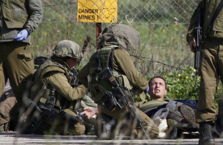 Un soldado israelí es atendido tras el fuego cruzado entre Hizulá y el Ejército israelí en los Altos del Golán. En el ataque ha muerto un militar español, por fuego israelí