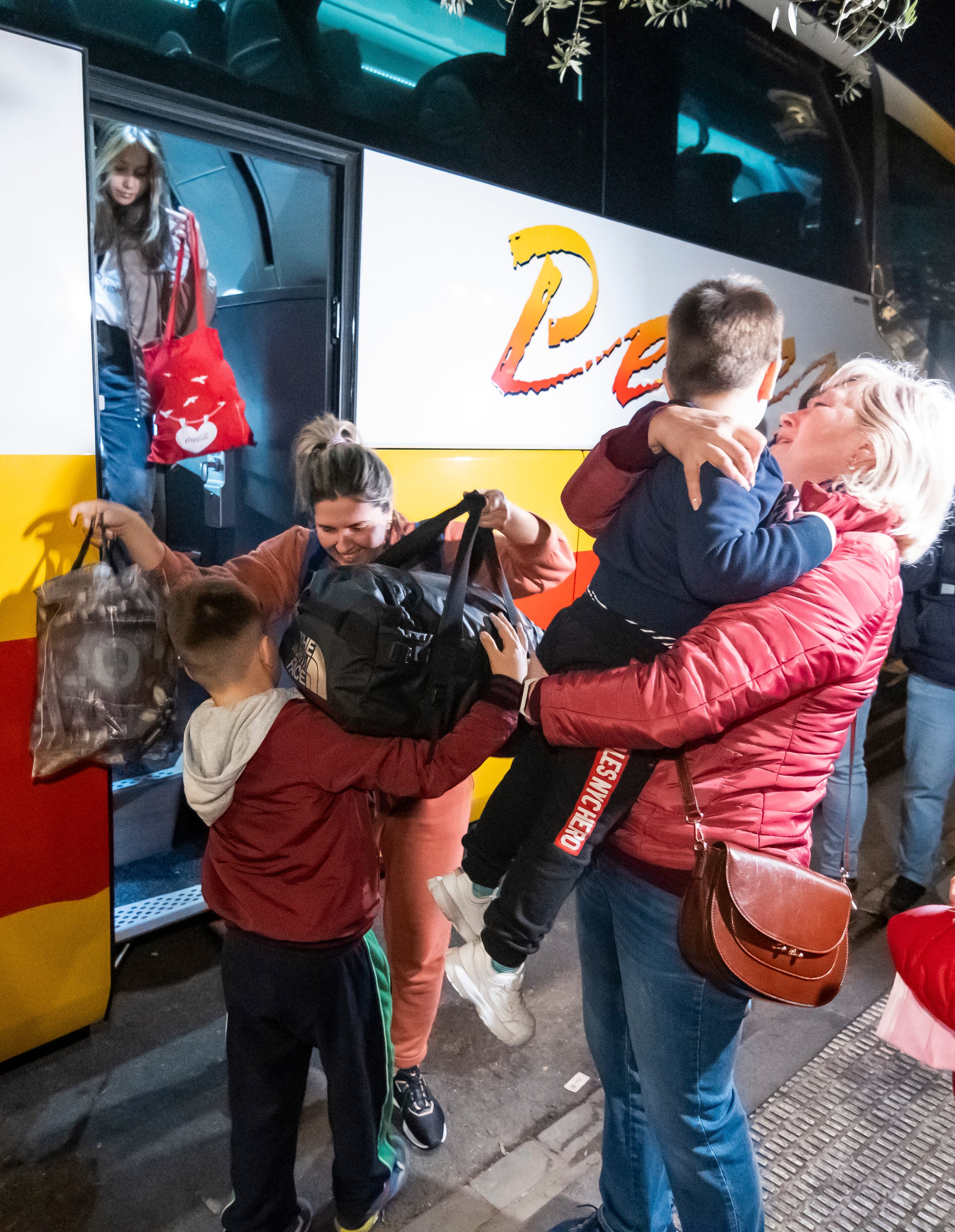 GRAF3570. SEVILLA, 08/03/2022.- Refugiados ucranianos bajan de un autobús que ha llegado desde Ucrania a Sevilla, y que terminará su periplo esta noche en Huelva, en un viaje que ha coordinado el párroco ucraniano Dmytro Savchuk, que lleva una iglesia ortodoxa en la ciudad onubense. EFE/ Raúl Caro.