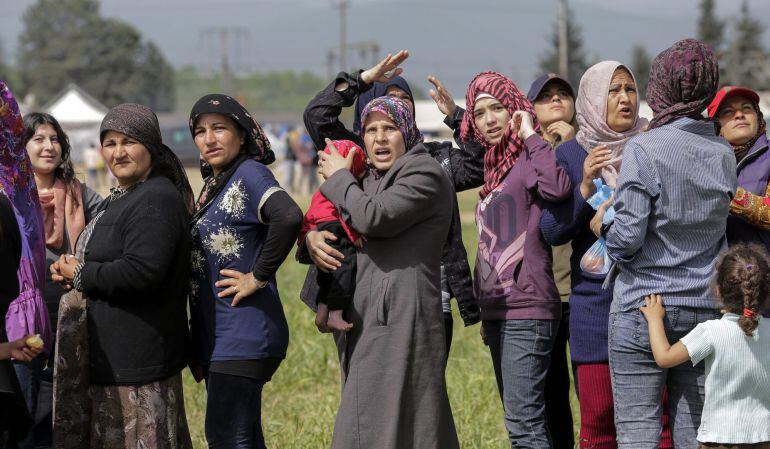 Refugiados reaccionan al ver cazas sobrevolar el campo de refugiados en Idomeni (Grecia)