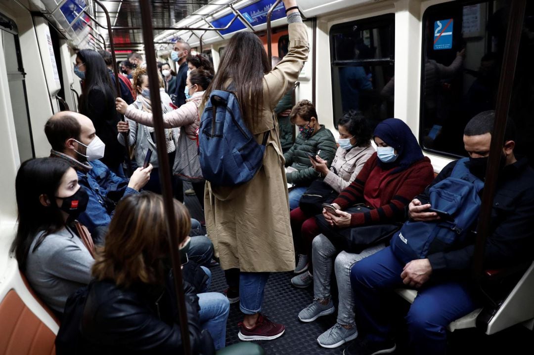 Varias personas viajan en la línea 1 del Metro de Madrid este lunes, primer día laborable de las nuevas restricciones