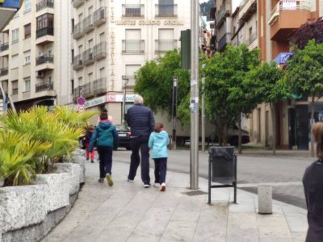 Dos niños con un adulto en el primer día de paseos controlados de los menores.