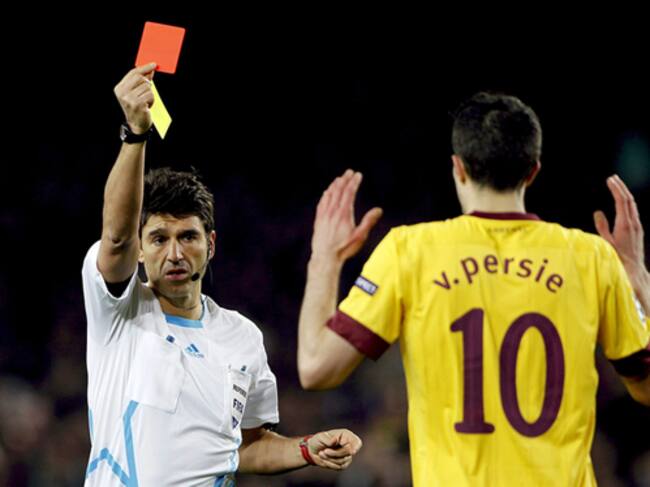 El árbitro suizo Massimo Bussaca saca la tarjeta roja al delantero holandés del Arsenal Robin Van Persie durante el encuentro correspondiente a la vuelta de los octavos de final de la Liga de Campeones, que el club disputa frente al FC Barcelona esta noch