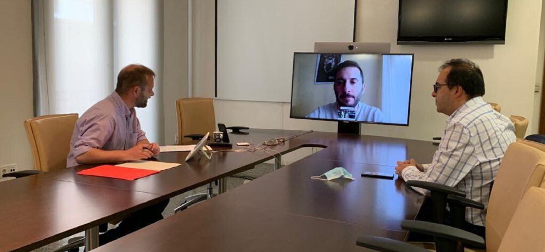 El alcalde, Santiago Llorente, (d) y el concejal de Empleo, Fran Muñoz, durante el encuentro telemático mantenido con los agentes sociales, entre ellos Raúl Cordero (CCOO), que es quien aparece en la pantalla