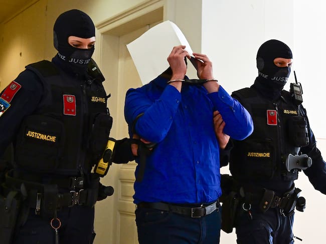 El acusado Beran A. es escoltado fuera de la sala de audiencias durante un descanso en la primera jornada del juicio por el complot contra el concierto de Taylor Swift, celebrado en el Tribunal Regional de Wiener Neustadt el 28 de abril de 2026 en Wiener Neustadt, Austria.