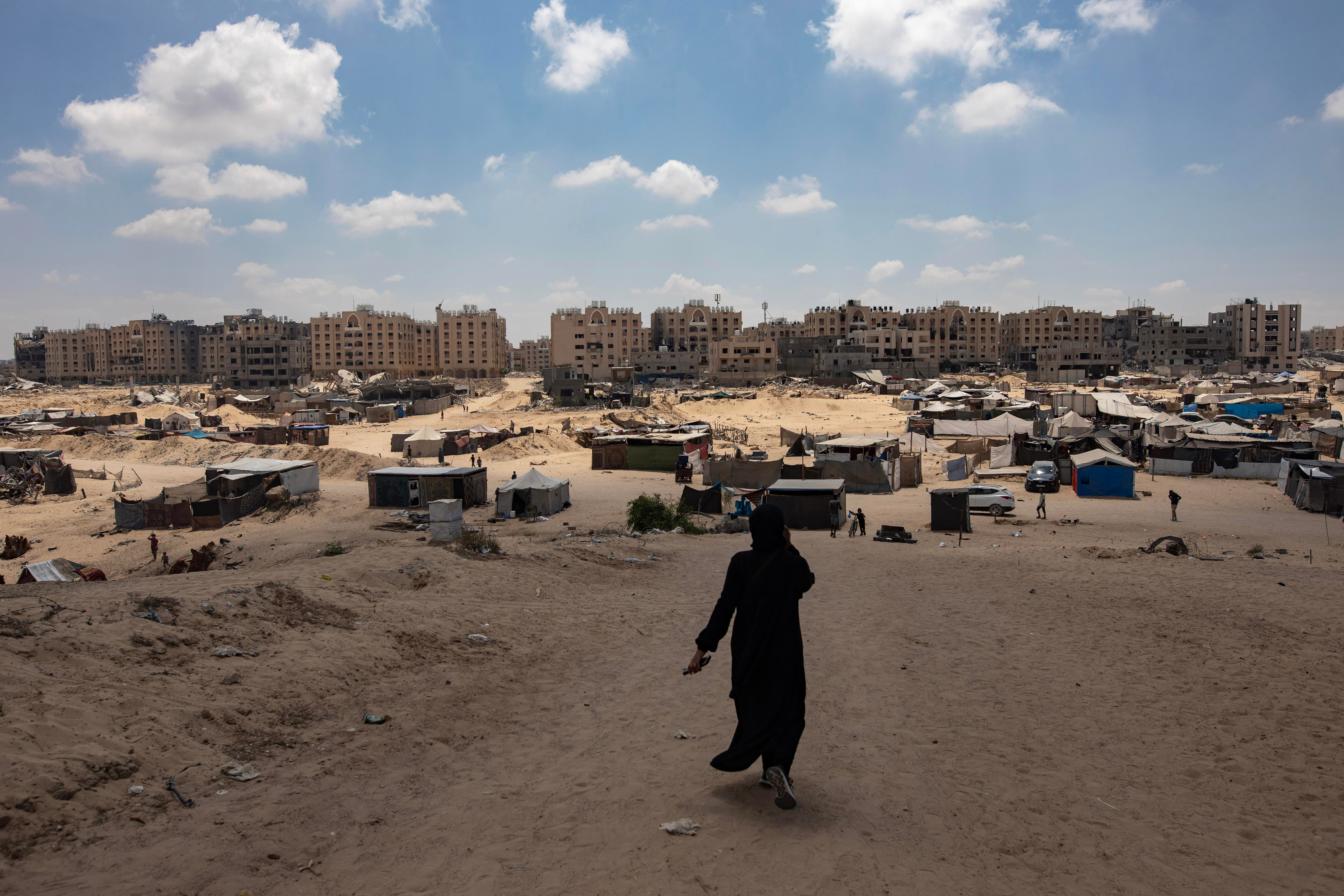 Una mujer pasea por un área de Gaza en la que ciudadanos palestinos has establecido un asentamiento tras abandonar sus casas por los ataques israelíes.