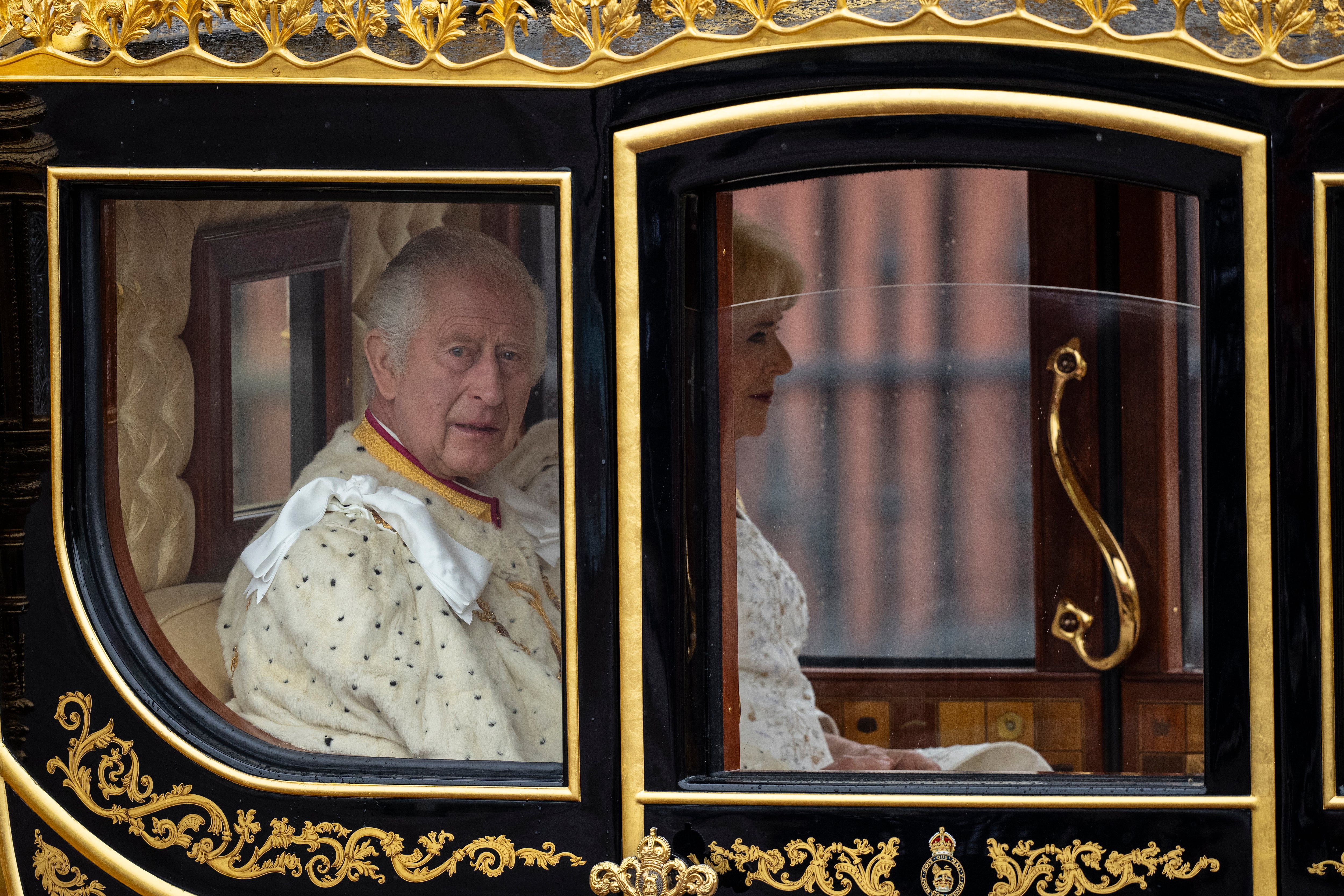 Carlos III de Inglaterra haciendo tiempo a que llegara su hijo en la carroza Jubileo de Diamante junto a Camila