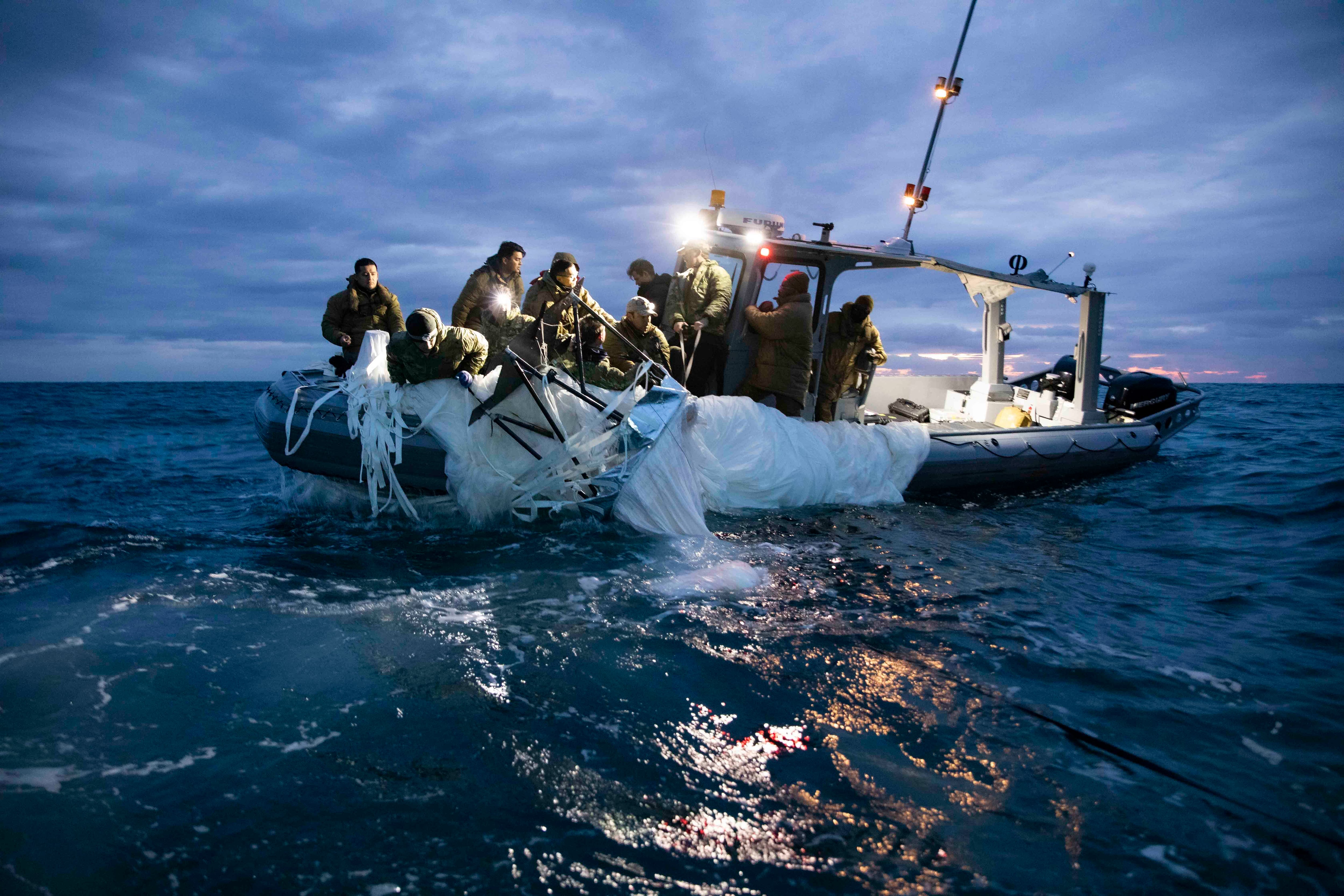 Fotografía cedida por la Armada de Estados Unidos donde aparecen unos marineros asignados al Grupo 2 de Eliminación de Artefactos Explosivos mientras recuperan el globo de vigilancia chino del mar