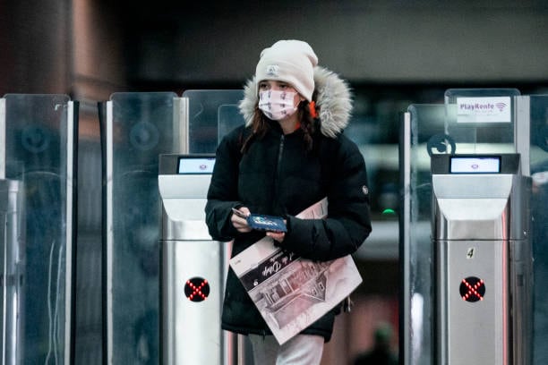 Una mujer con mascarilla accede al Cercanías.