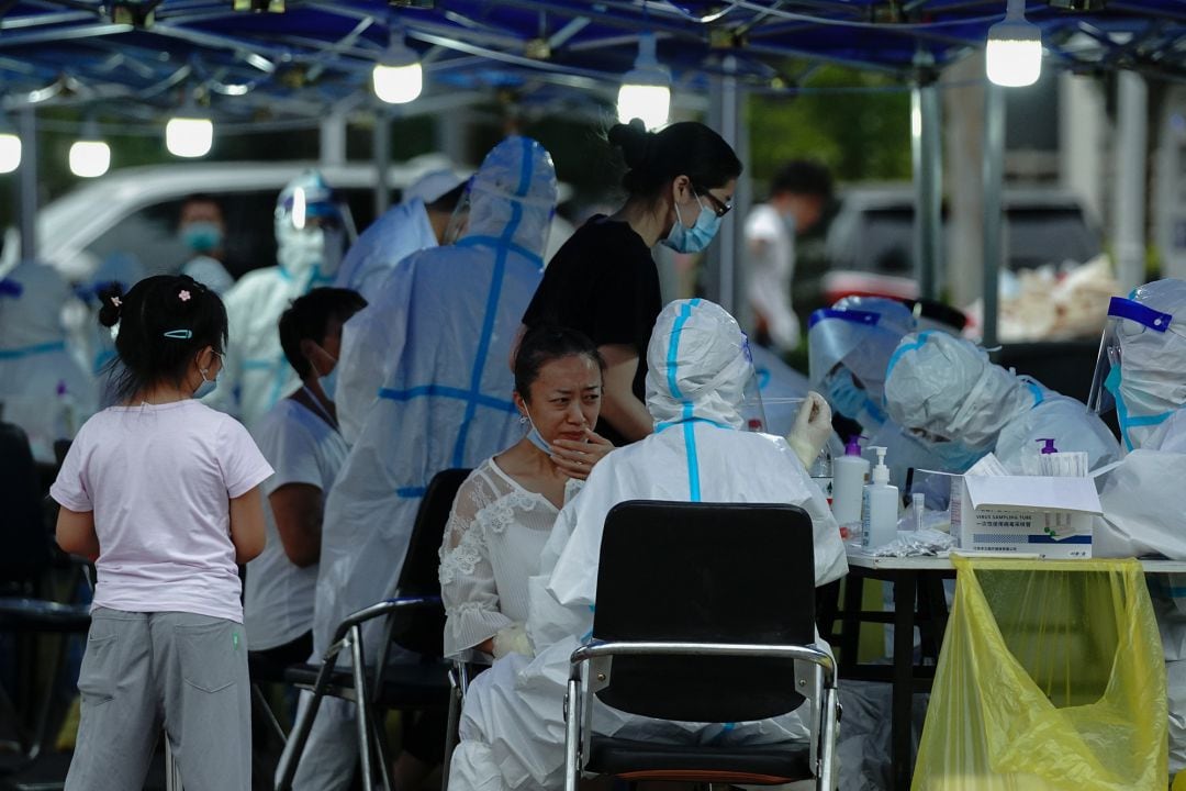 Un trabajador médico usa un traje de protección para hacer una prueba de coronavirus en Pekín