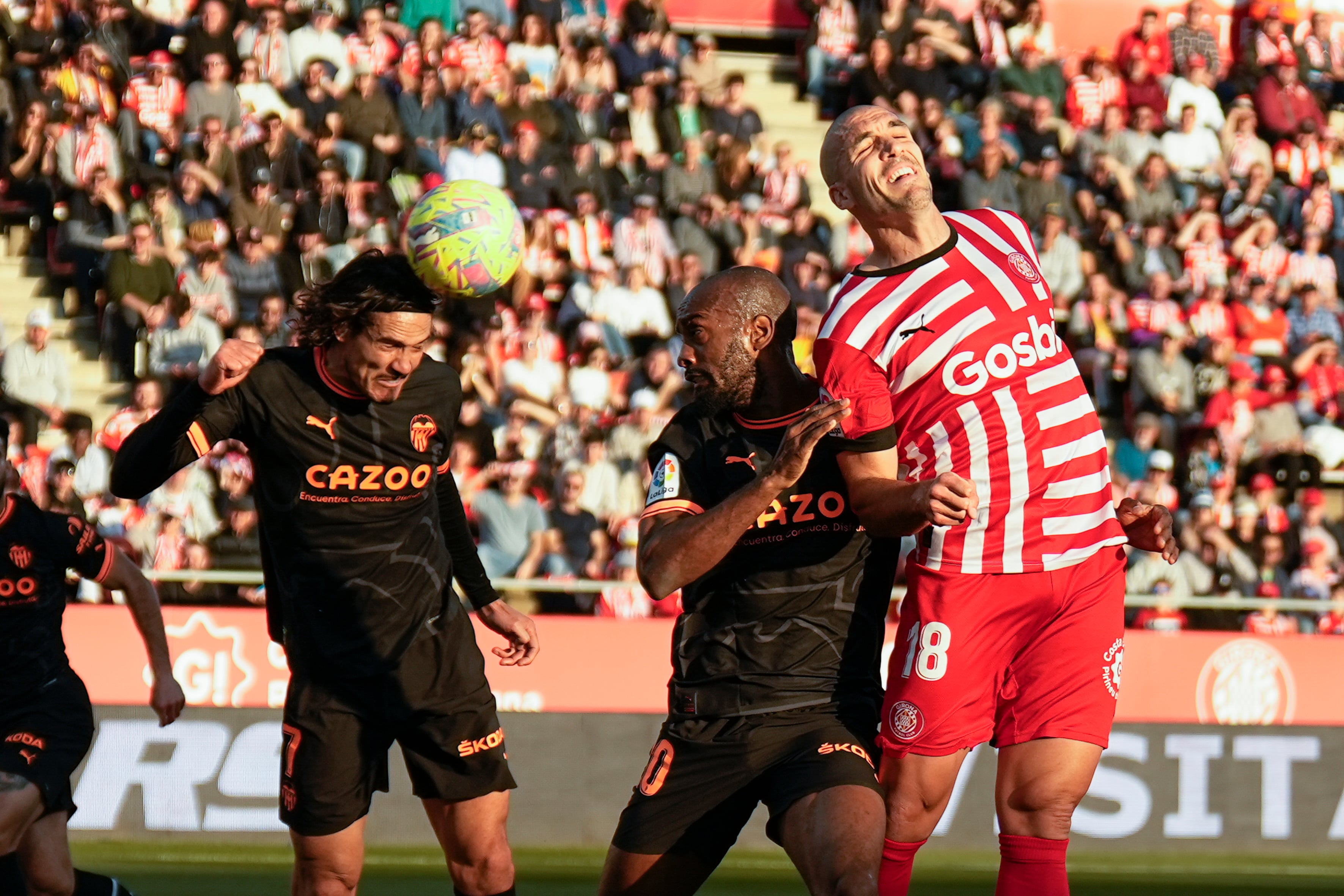El delantero del Valencia, Edinson Cavani y el defensa Dimitri Foulquier disputan un balón con Oriol Romeu, centrocampista del Girona durante el partido de LaLiga Santander en el estadio municipal de Montilivi de Girona. EFE/David Borrat