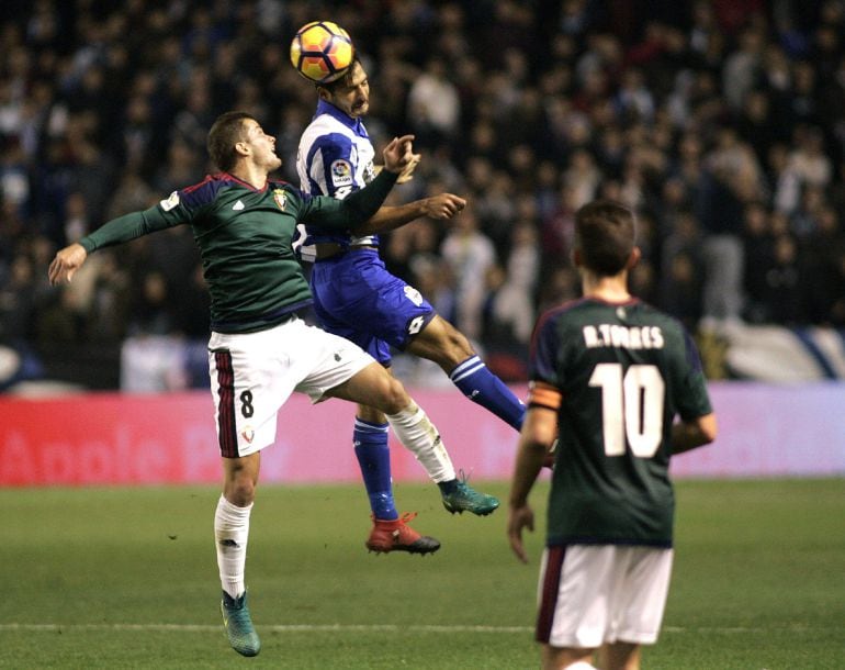 Causic disputa un balón ante la mirada de Torres