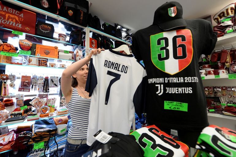 Una mujer coloca en su tienda una camiseta de Cristiano de la Juventus