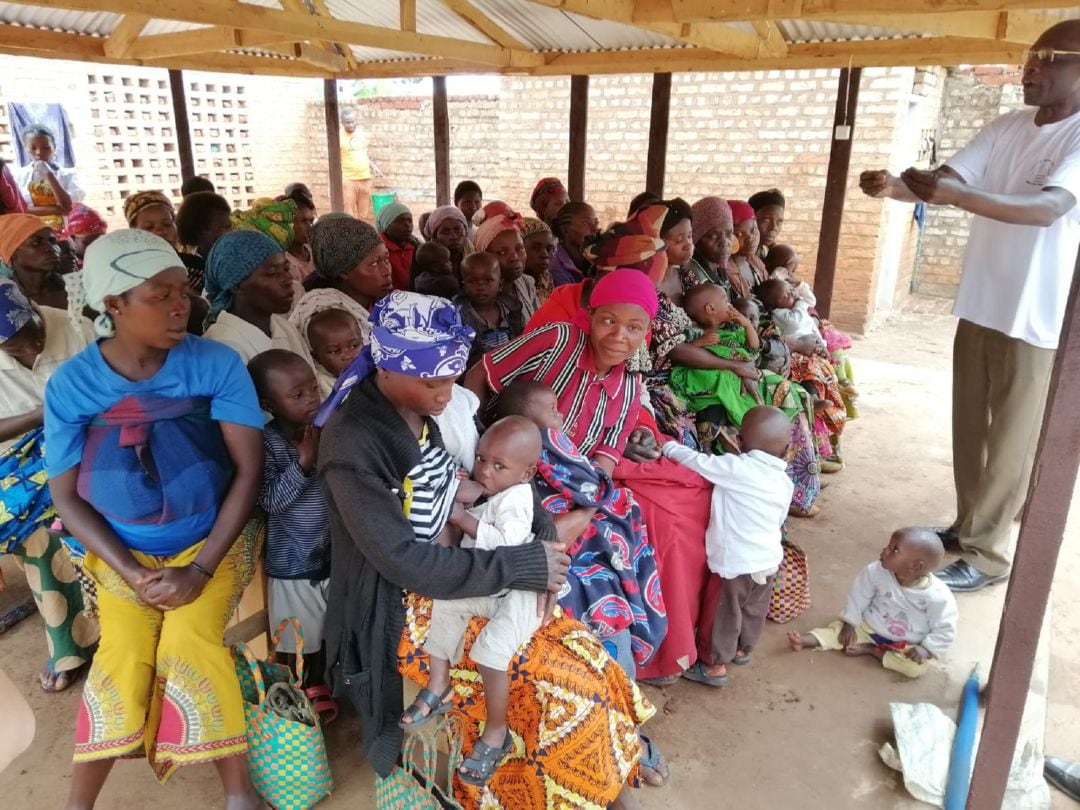 Mujeres con sus hijos recibiendo enseñanza sobre nutrición