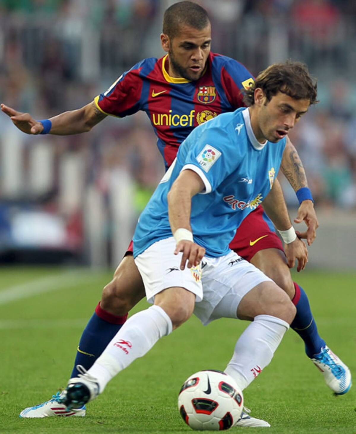 El centrocampista argentino de la UD Almería Hernán Bernardelloprotege un balón ante el defensa brasileño del F.C. Barcelona Dani Alves durante el partido correspondiente a la trigésima primera jornada de Liga