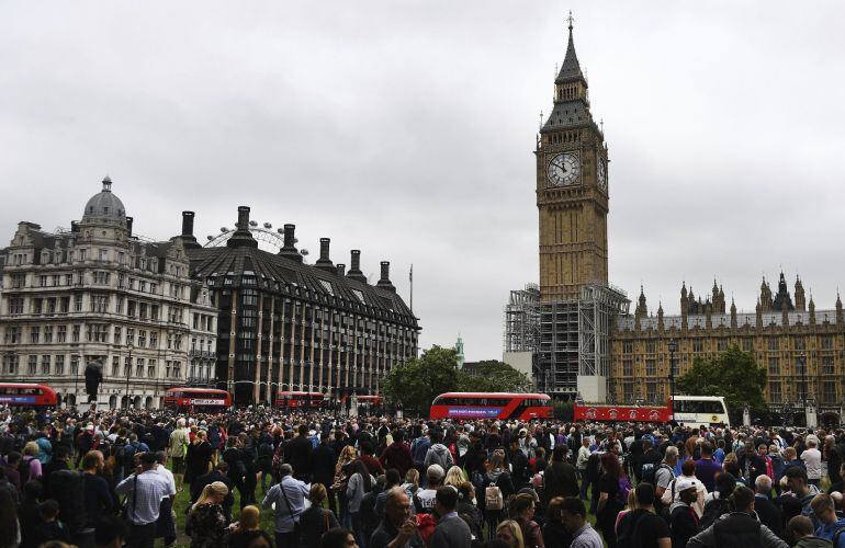 Decenas de personas se reúnen frente al reloj del Big Ben mientras su campana repica por última vez en Londres.