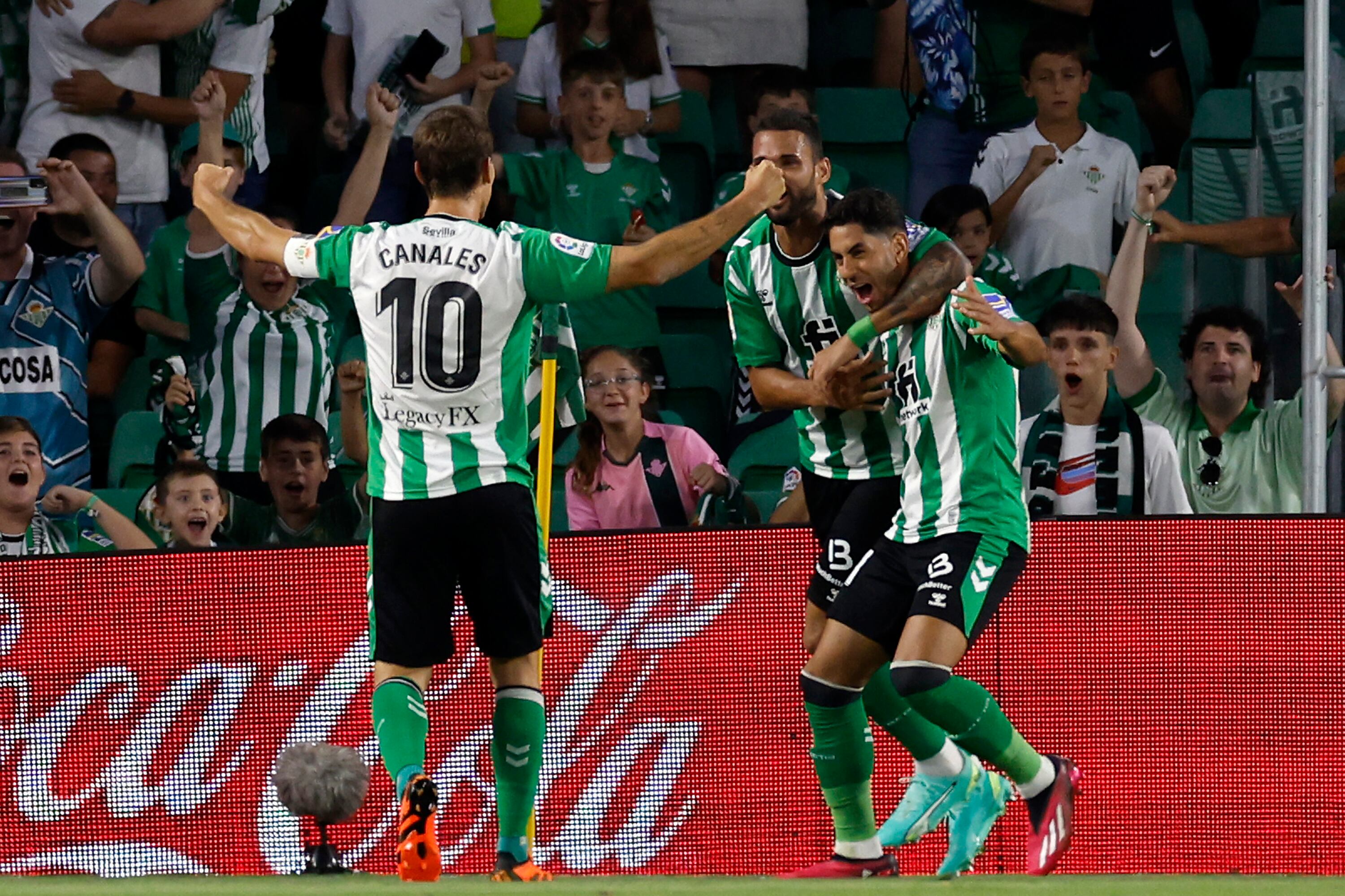 SEVILLA, 15/05/2023.- Los jugadores del Betis, (i-d) Sergio Canales, el brasileño Willian José y Ayoze Pérez, celebran el segundo gol del equipo bético durante el encuentro correspondiente a la jornada 34 de primera división que disputan hoy lunes frente al Rayo Vallecano en el estadio Benito Villamarín de Sevilla. EFE/Julio Muñoz.
