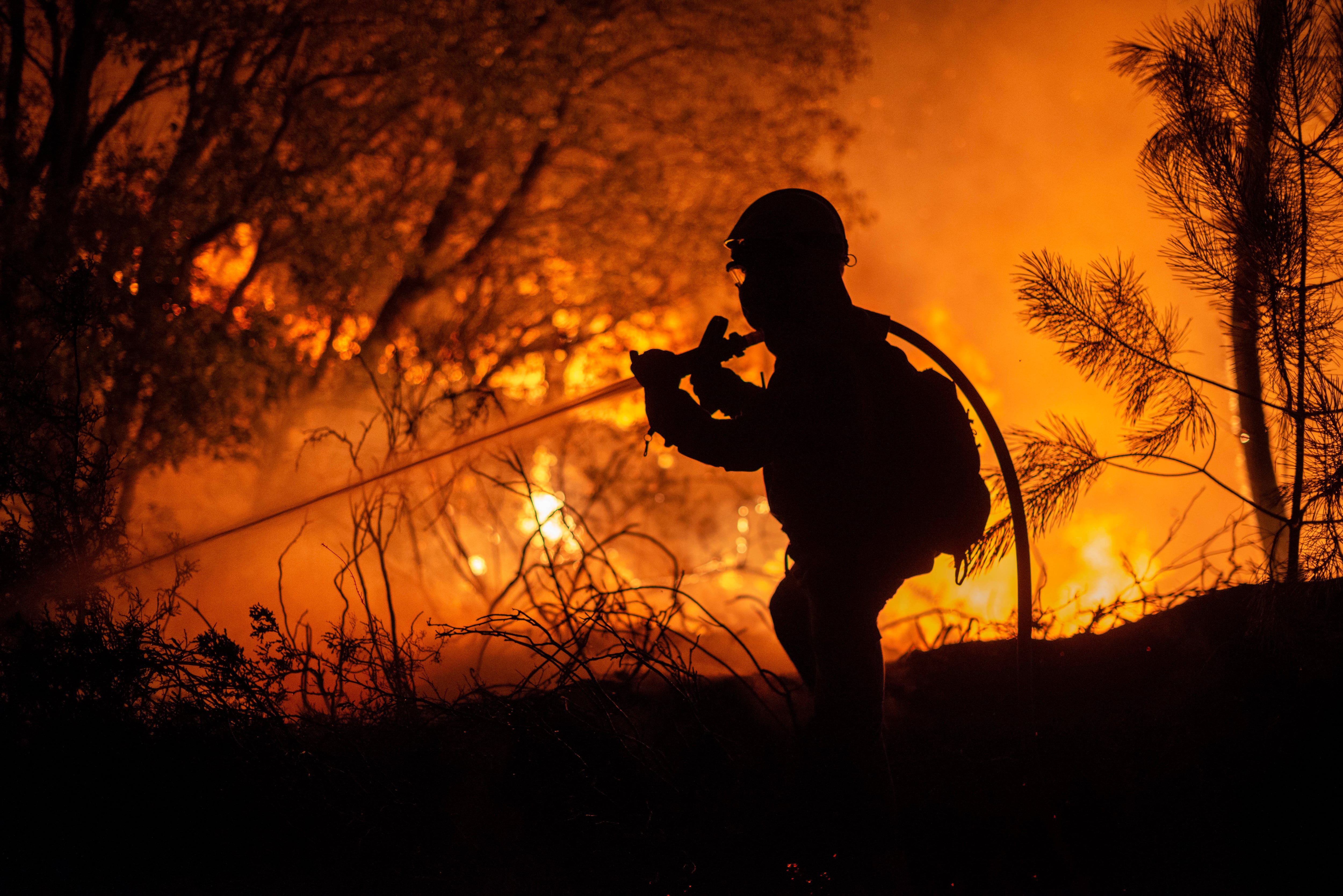 Un bombero participa anoche en la extinción de un incendio próximo al núcleo do Pereiro, en el municipio de Castrelo de Miño (Ourense)