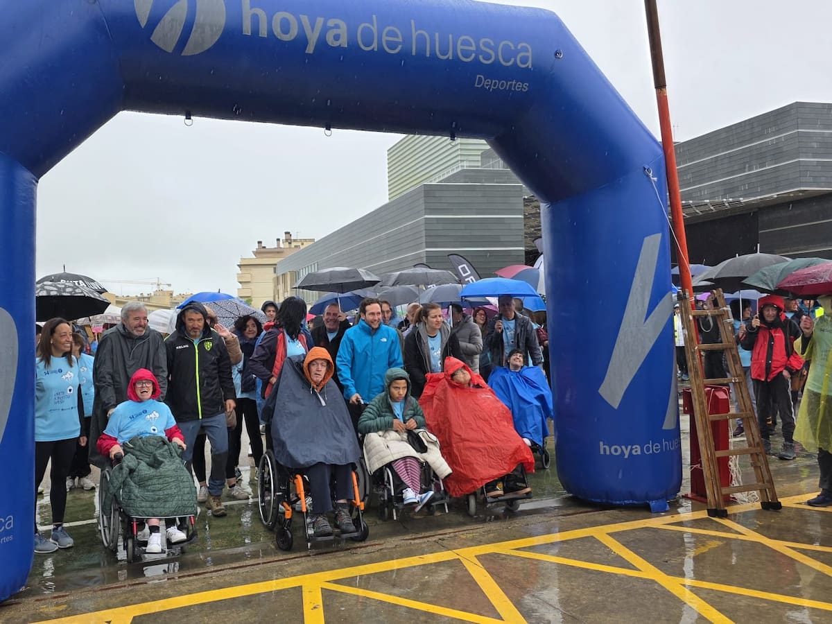 La Marcha Aspace planta cara a la lluvia para avanzar hacia su nueva residencia en la ciudad de Huesca