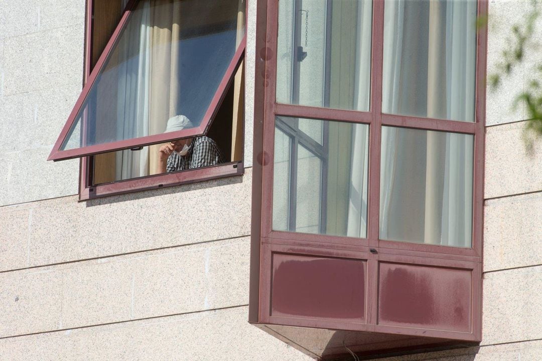 Un anciano se asoma a una venta en una residencia