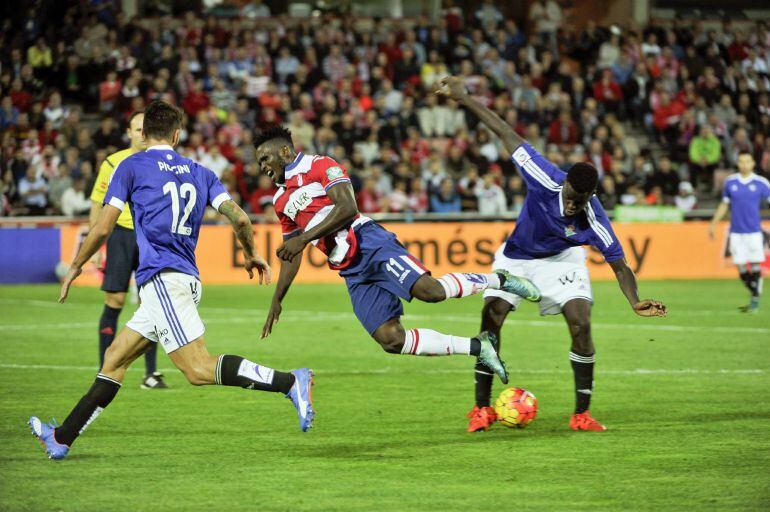 El centrocampista senegalés del Betis, Alfred N´Diaye (d), arrebata el balón al delantero nigeriano del Granada, Isaac Success Ajayi (c), durante el encuentro correspondiente a la novena jornada de primera división, que han disputado esta noche en el Estadio Nuevo los Carmenes de Granada.