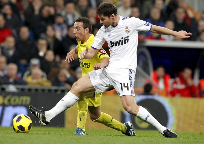 El mediocentro del Real Madrid Xabi Alonso (d) lucha por el balón con el centrocampista del Villarreal CF Santi Cazorla durante el partido, correspondiente a la decimoctava jornada de Liga de Primera División, que enfrenta a ambos equipos esta tarde en el