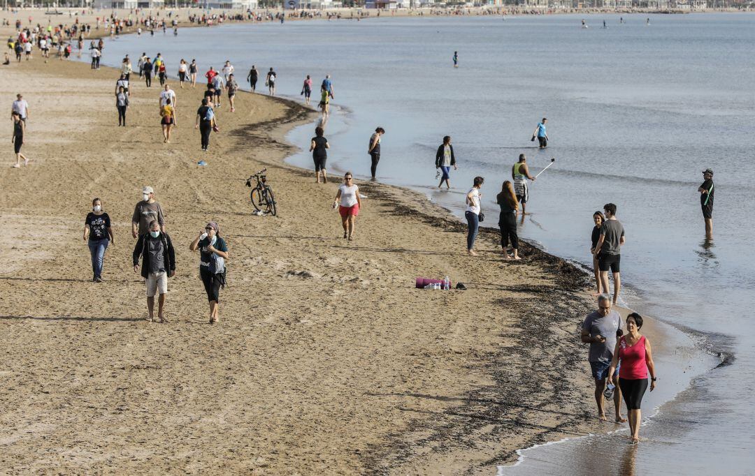 Personas paseando en la playa de la Malvarrosa el primer día de salida en València tras 48 días en casa por el coronavirus, en que los adultos pueden salir a pasear y a hacer deporte.