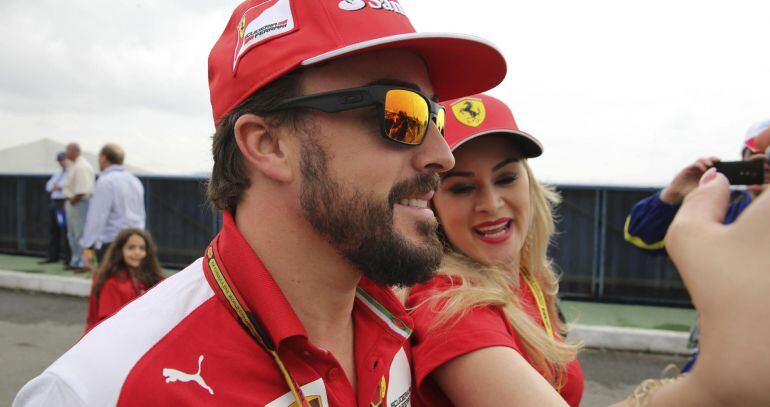 El piloto español Fernando Alonso, de la escuderia Ferrari, se fotografía con una fan en la entrada para el Gran Premio de Fórmula Uno de Brasil, que se disputa hoy en el circuito del autódromo de Interlagos.