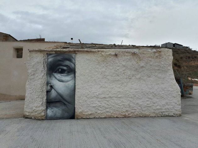 Una puerta decorada con el rostro de una anciana