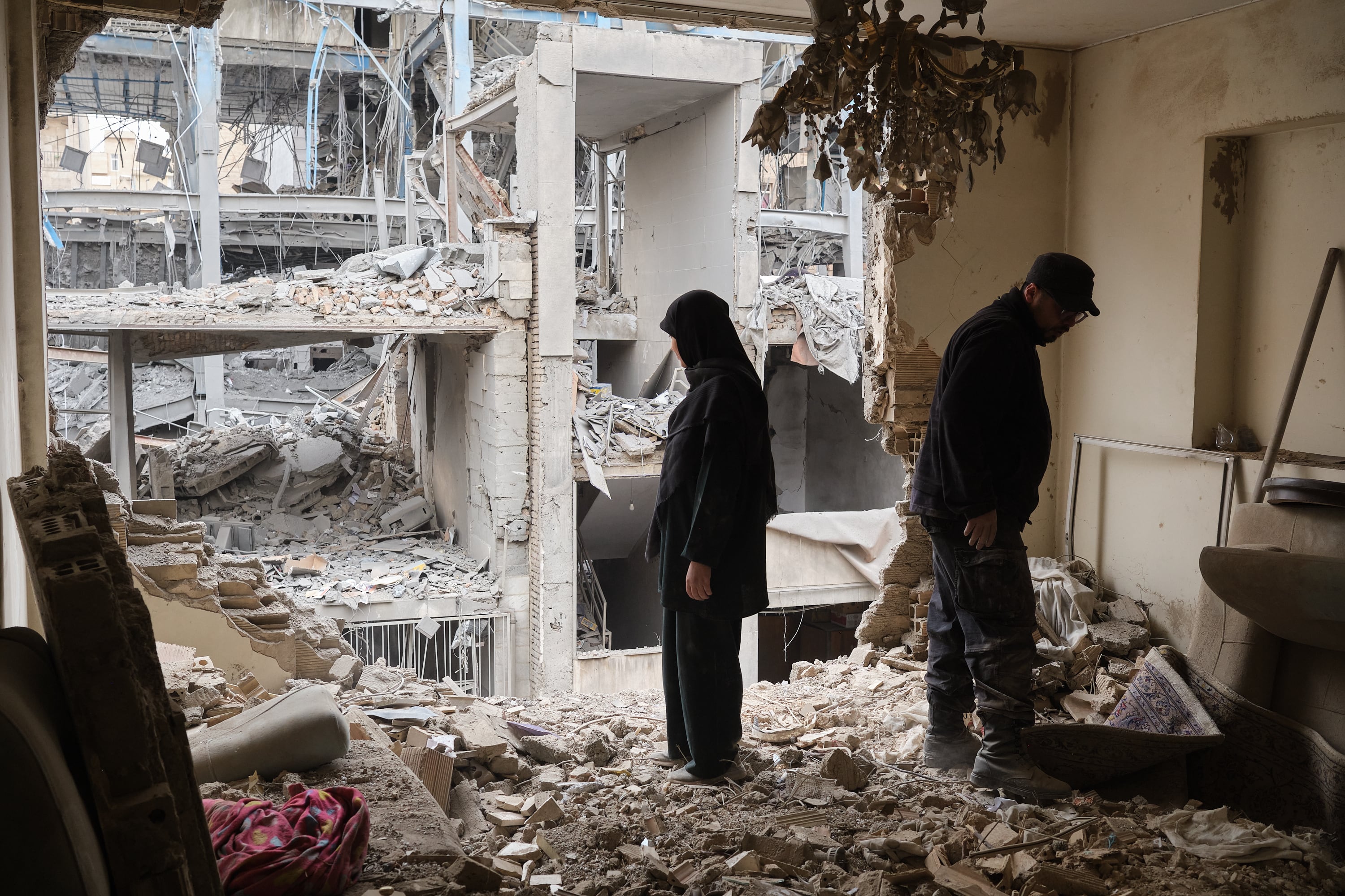 Un pareja desescombra una vivienda en el barrio de Haft Chenar de Teherán que resultó dañada en un ataque de Estados Unidos e Israel.