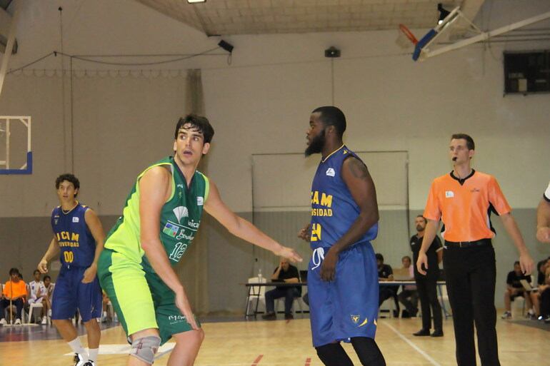 El alero del Unicaja, Carlos Suarez, defiende al jugador del Murcia Davis.