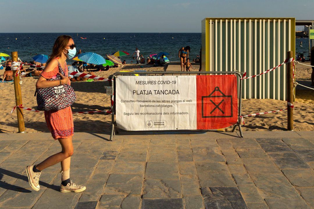 Cartel informativo del cierre de la playa por alcanzar el máximo del aforo permitido por seguridad, este sábado en Barcelona.