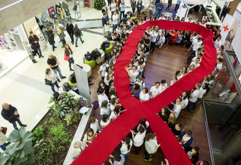 Miembros de la Cruz Roja Juventud húngara sostienen una cinta roja gigante, símbolo del Sida, con motivo de la celebración del Día Mundial de la Lucha contra el Sida en Budapest, Hungría, hoy 1 de diciembre de 2015