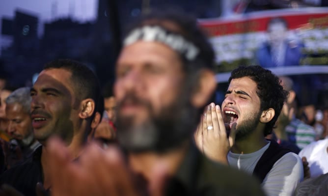 Un partidario del depuesto presidente egipcio, Mohamed Mursi asiste a las oraciones nocturnas durante una protesta frente a la mezquita Adawiya Rabaa