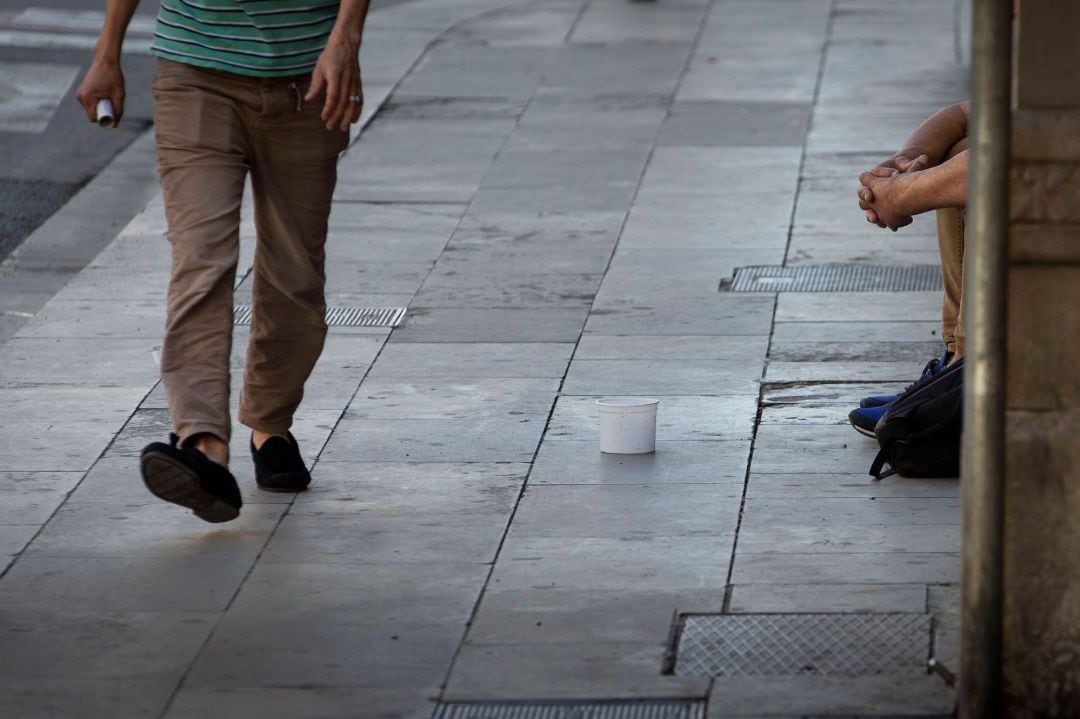 Un hombre pide limosna en la calle.