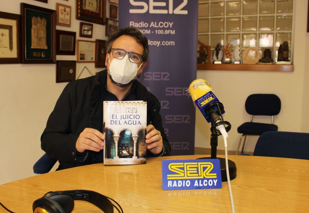 Juan Francisco Ferrándiz, con un ejemplar del libro &#039;El juicio del agua&#039; en los estudios de Radio Alcoy