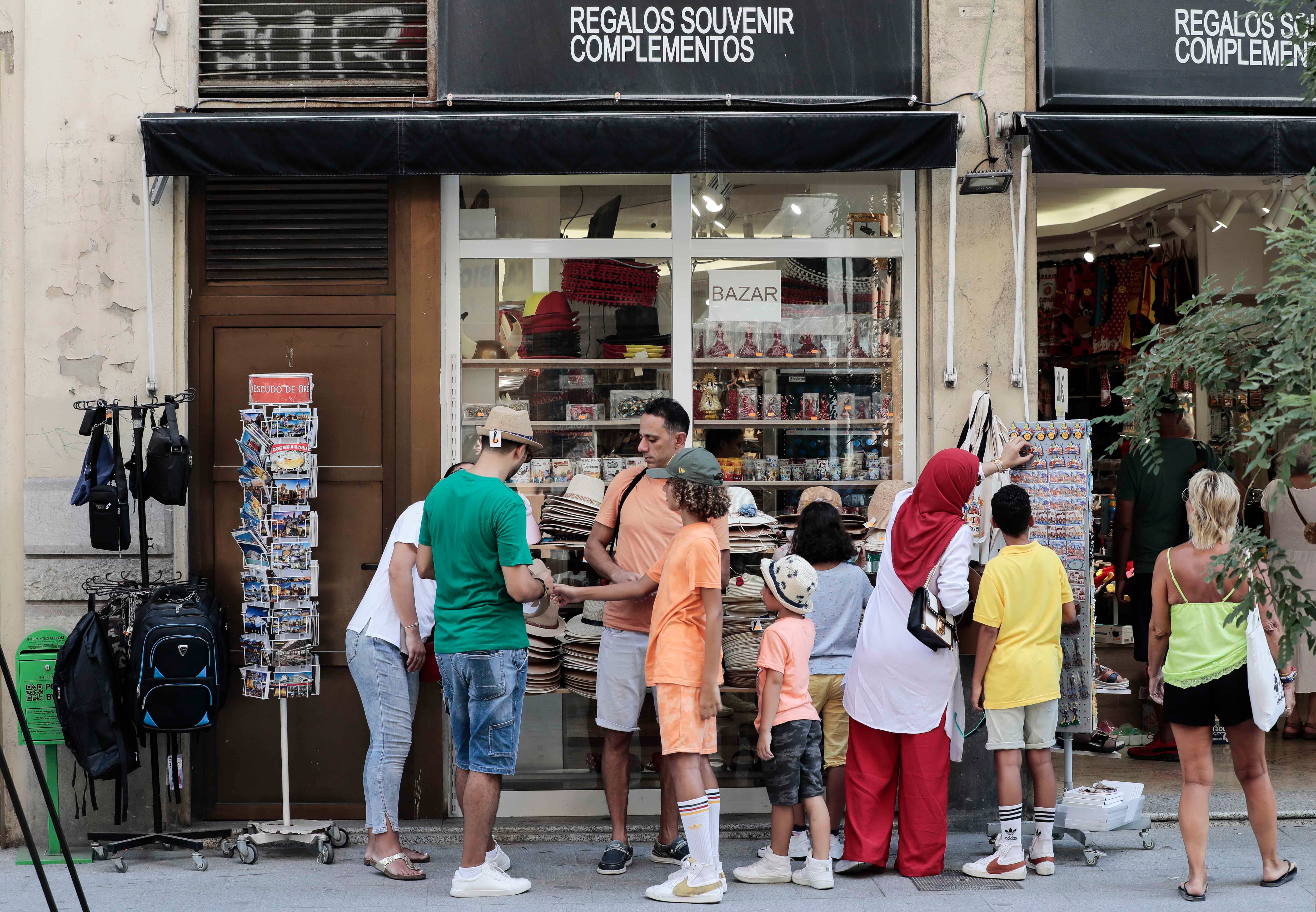 Varios turistas eligen souvenirs en una tienda del centro de Valencia